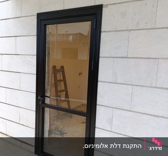 התקנת דלת אלומיניום שחורה עם זכוכית בקיר חיצוני